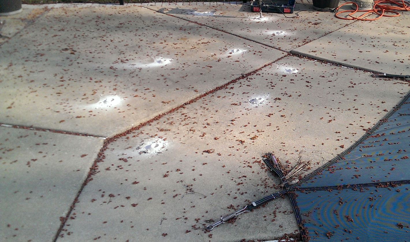 Grout ports patched flush across a raised concrete pool deck